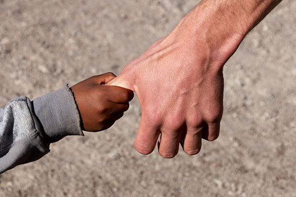 Child's hand holding an adult's thumb