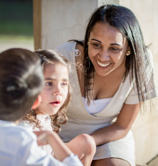 A women in a class helping younger students. 